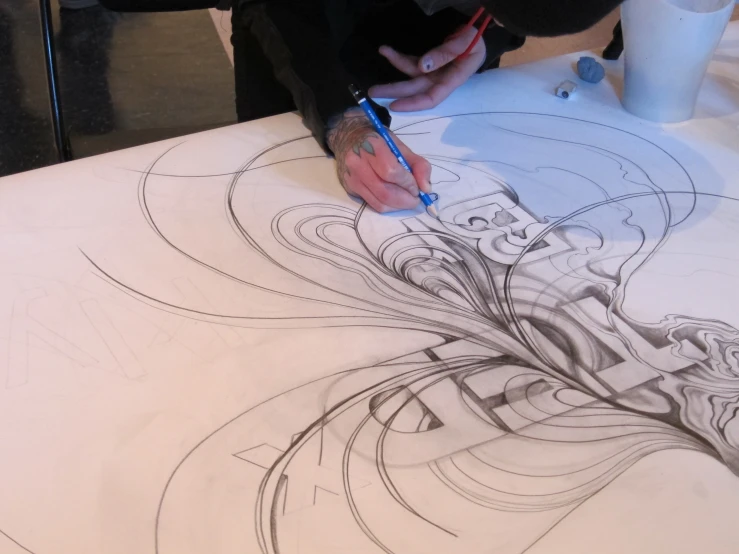 someone drawing a design on a table top