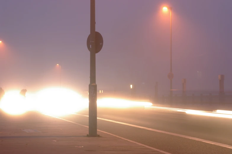 several cars are driving on a foggy road