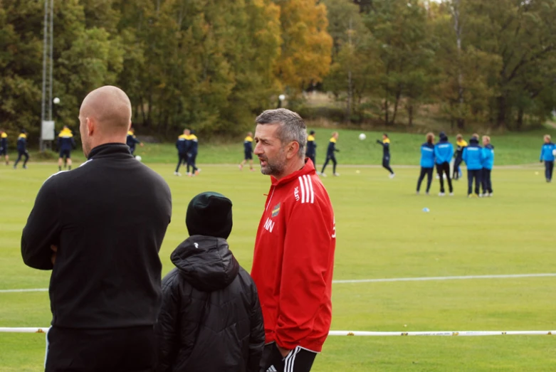 the soccer players are looking on as they talk