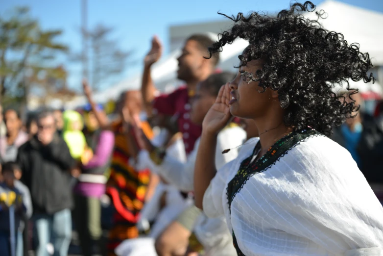 many people and one lady is standing with her hand in the air