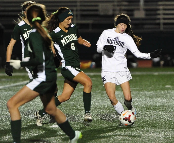 two women are playing soccer on a field