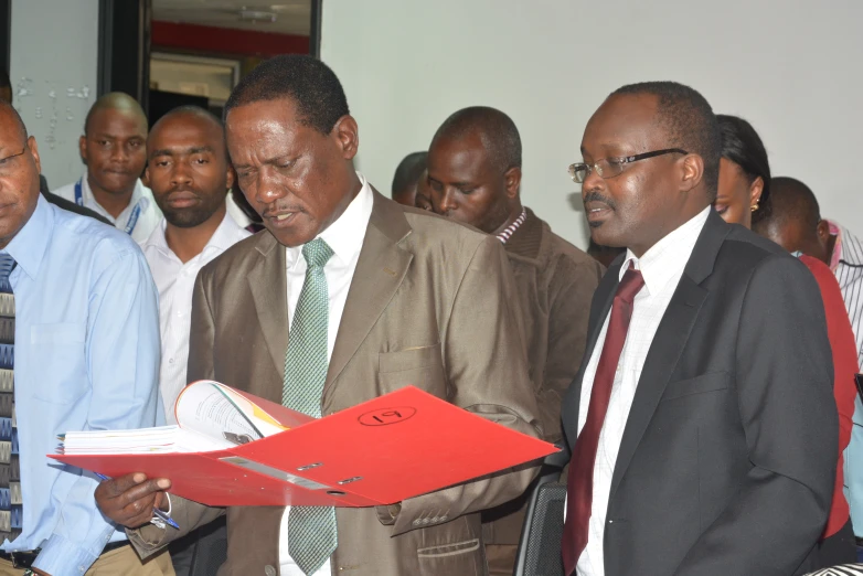 three men are standing together in suits and ties