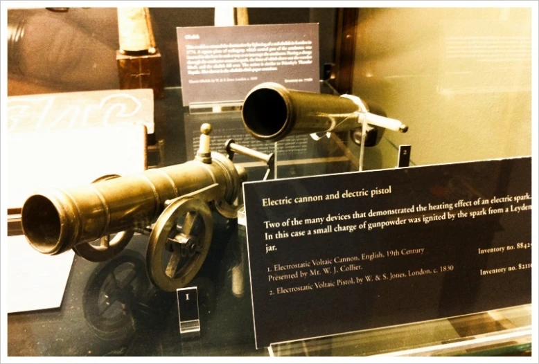 a telescope sitting on display next to a plaque