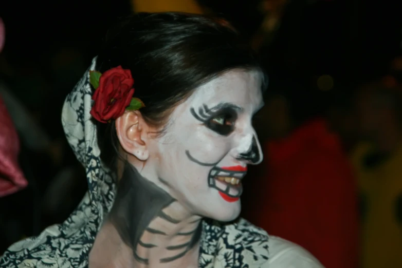 a person with face paint and a flower in their hair