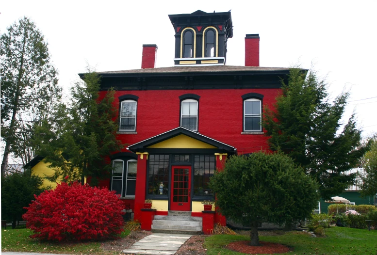 the building has many small red bushes and trees