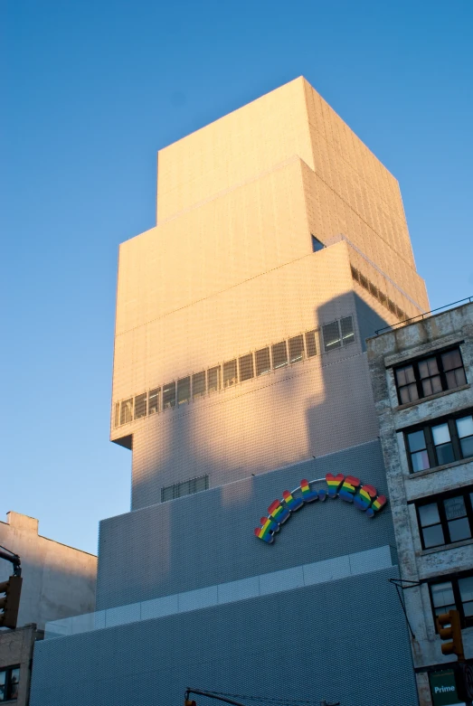 a very tall building in the city with a rainbow on it