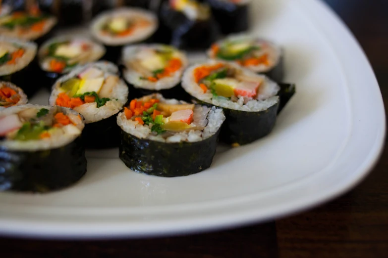 a white plate filled with rolls covered in meat