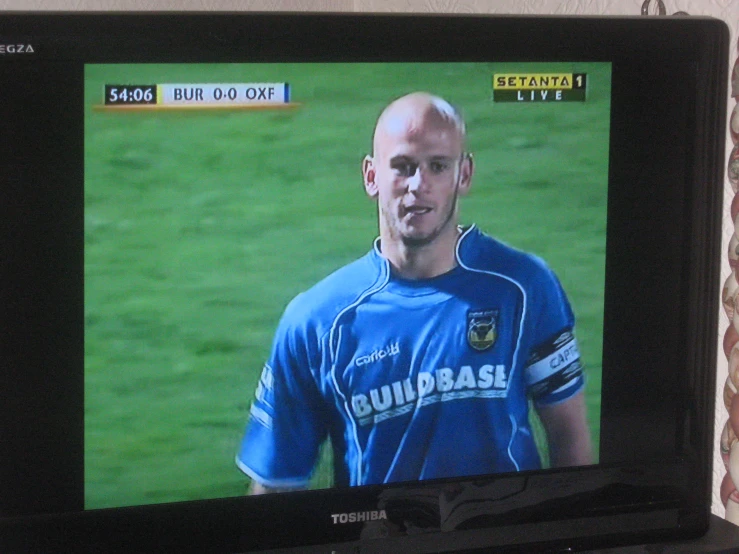 a man on a tv with a soccer game played on it