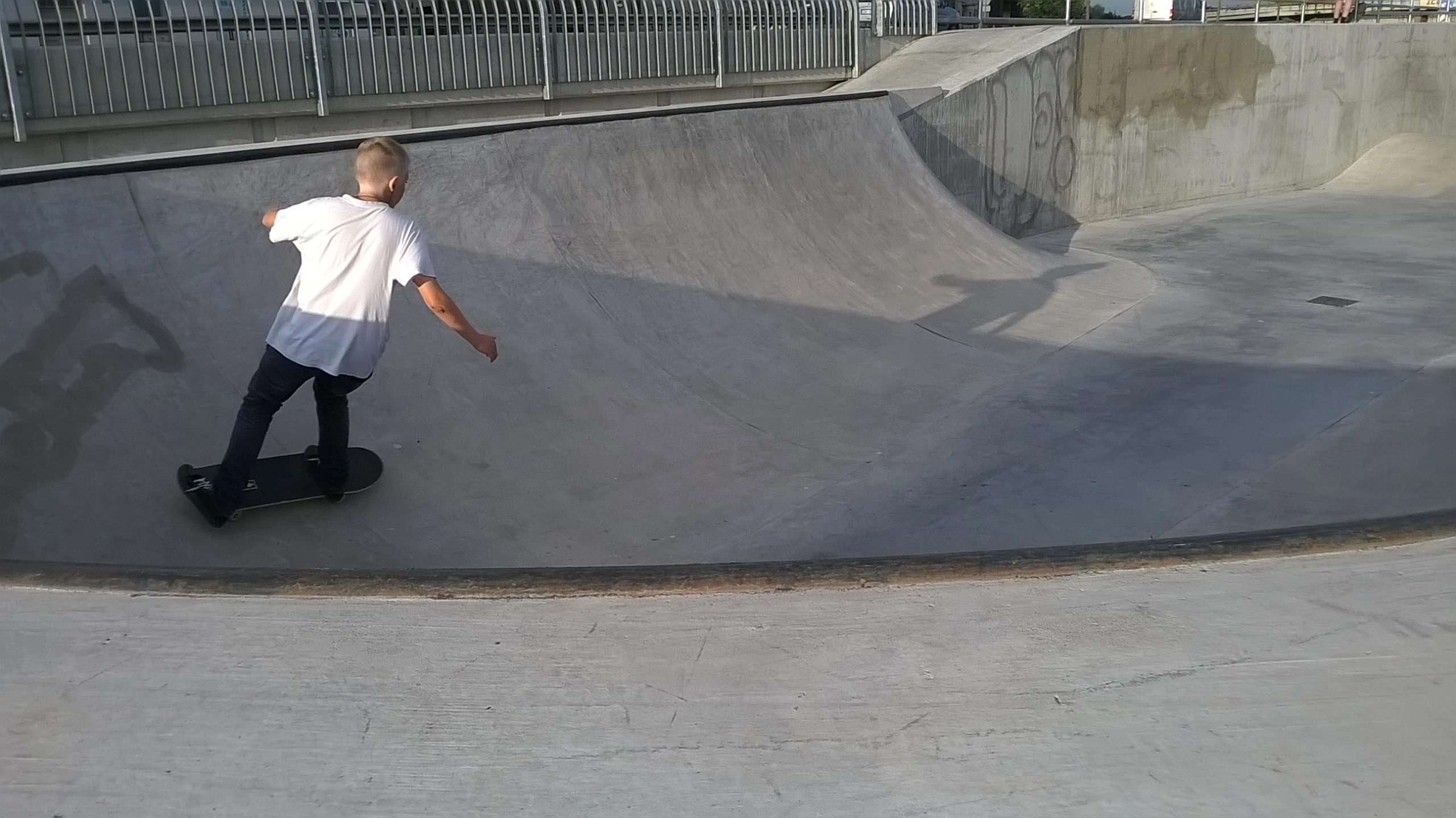 a boy skateboarding at a skate park in a skateboard park