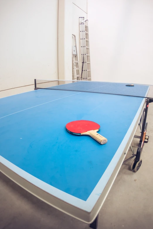 a ping pong paddle resting on a blue table