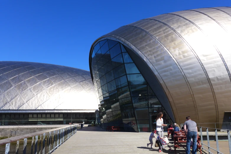 some people standing near a walkway and looking at an architectural structure