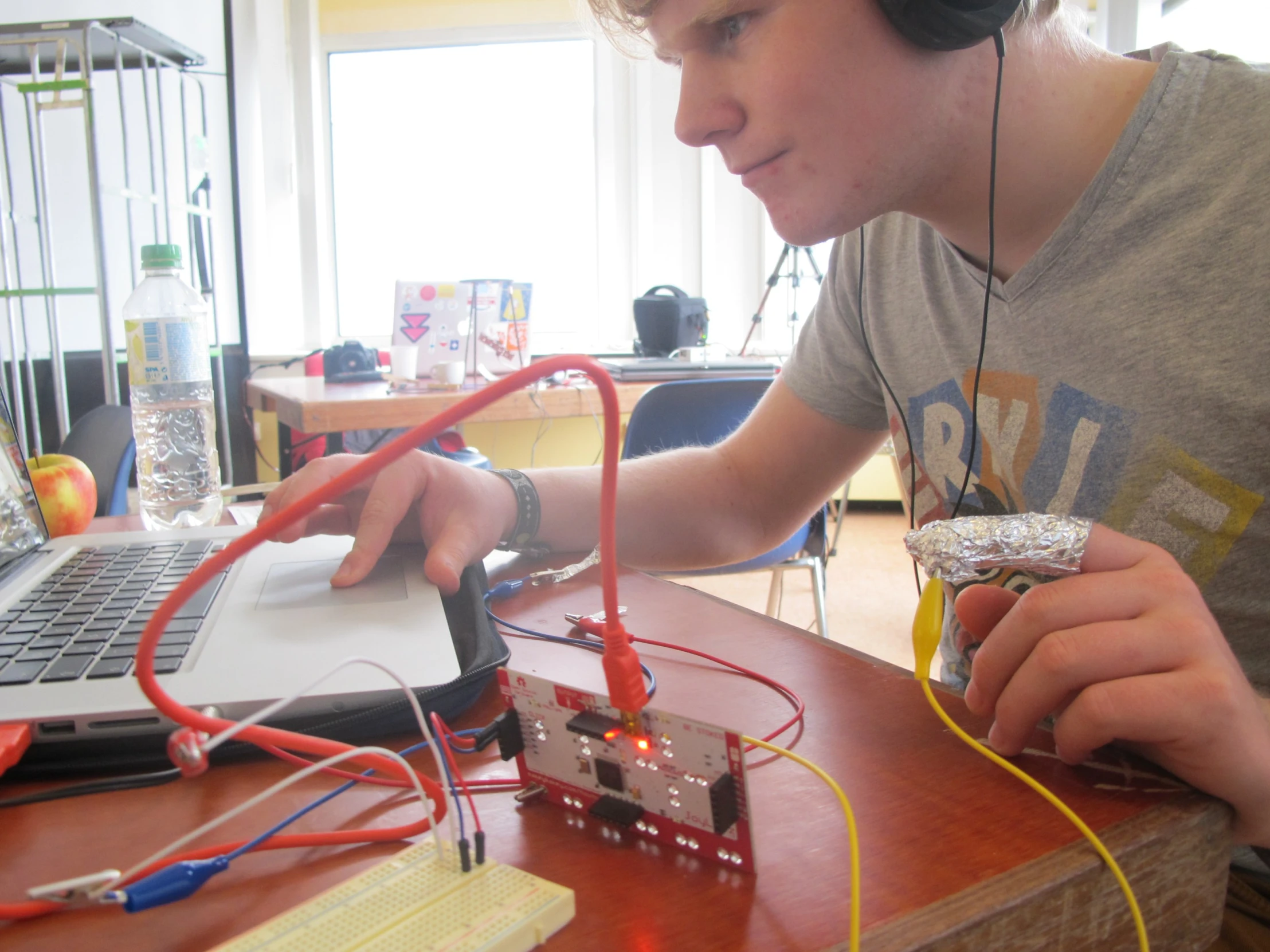 man looking at electronic components on laptop keyboard