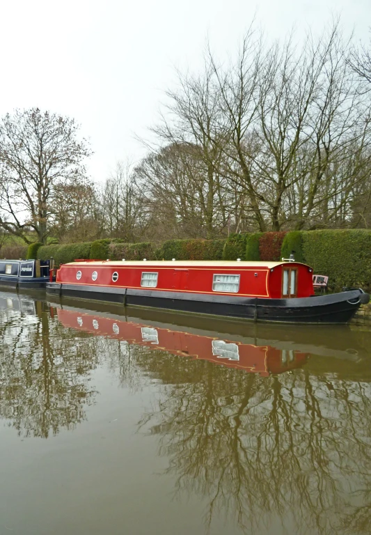 a long red boat that is sitting on the water