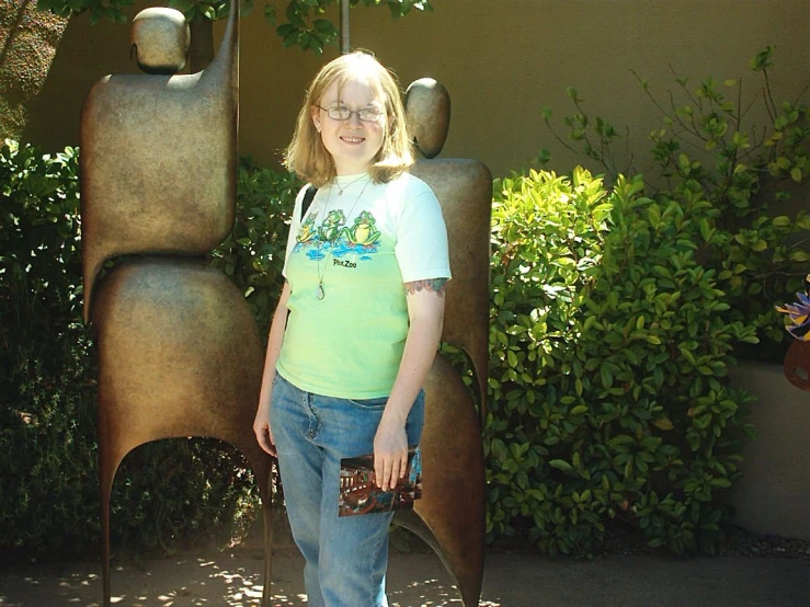 a young lady standing next to a statue