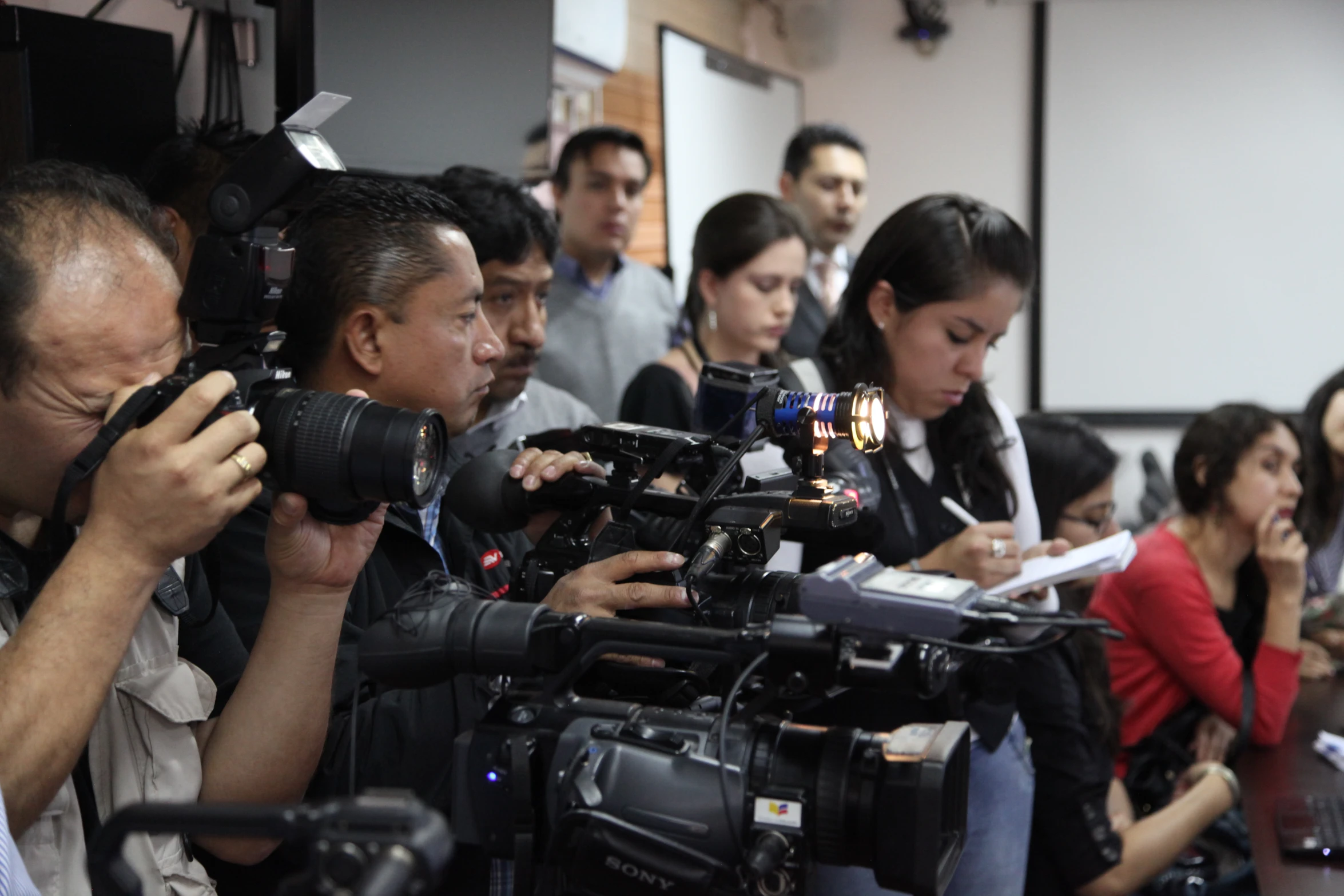 people in a group with camera equipment in their hands