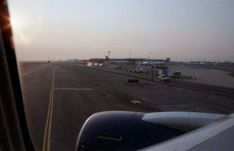 an airport with planes on the runway at sunset