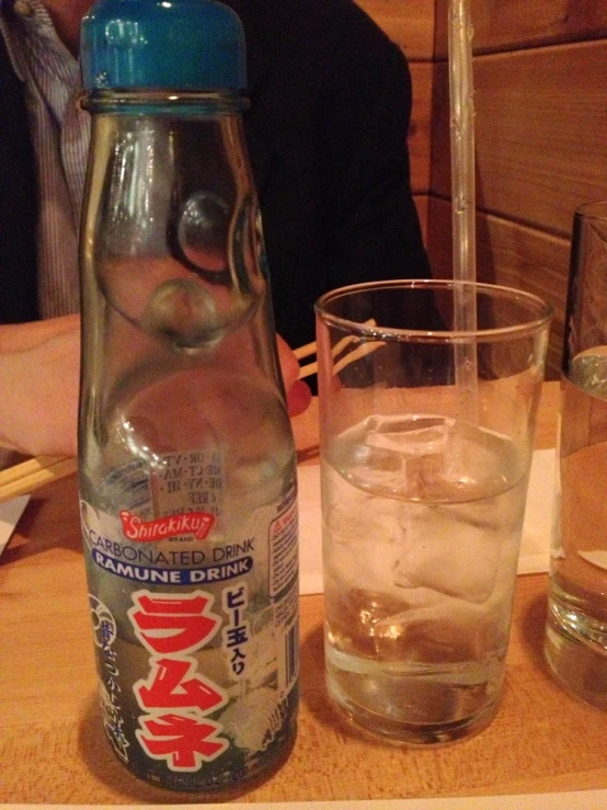 an open bottle of soda and glasses on a table