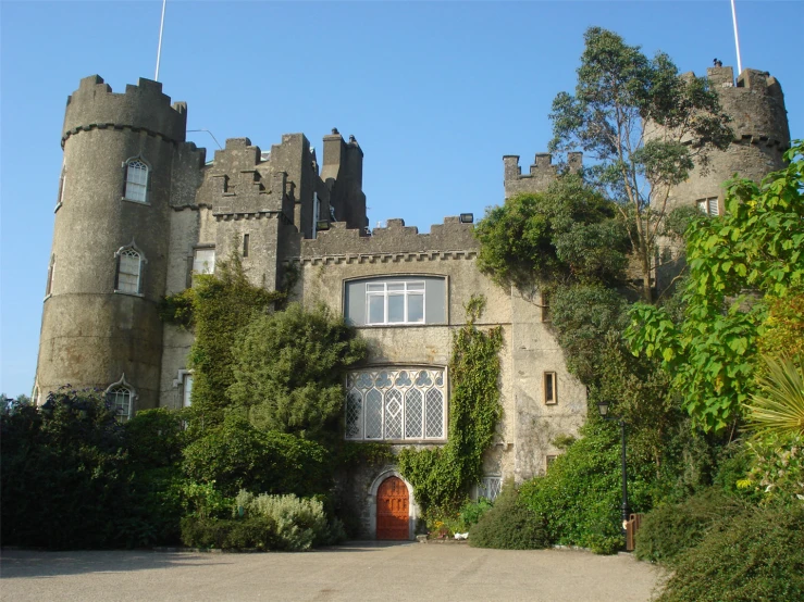 an old castle building with tall towers and ivy growing around it