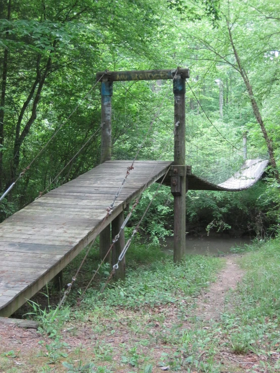 a wooden boardwalk and hammock hanging over the path