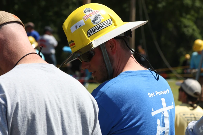 people standing in line wearing yellow safety hats
