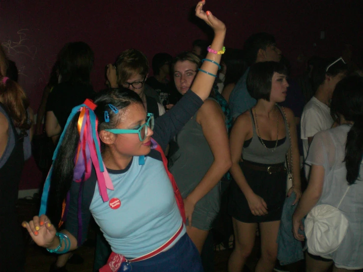 young adults dancing at party in room with many people