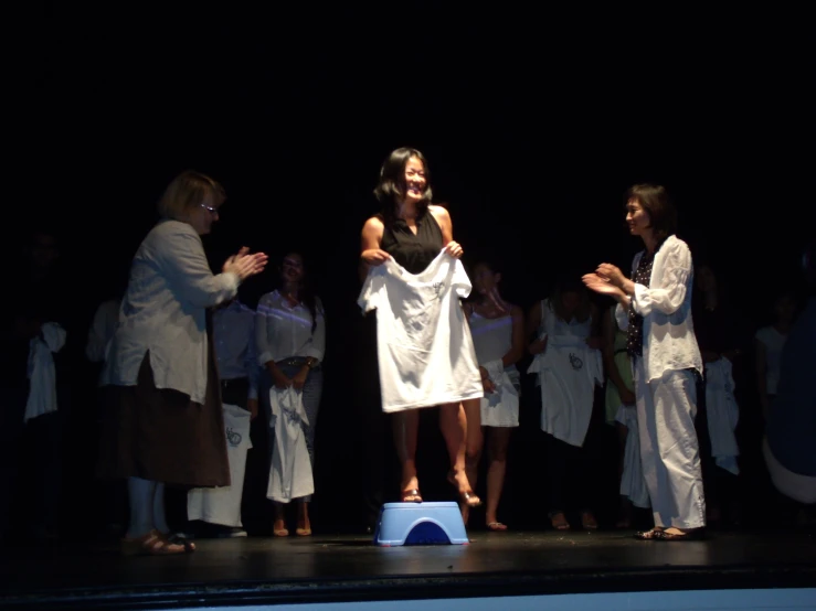 women in robes standing on stage in performance