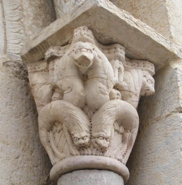 an ancient stone gargoyle with figures on it's face