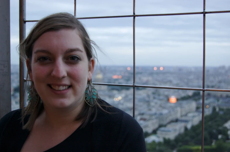 a woman in front of a window with some lights