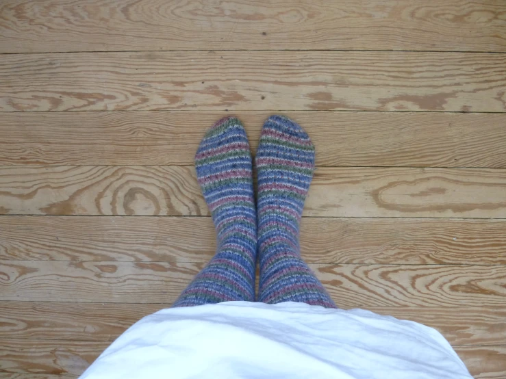 a woman's legs with blue socks and purple shoes