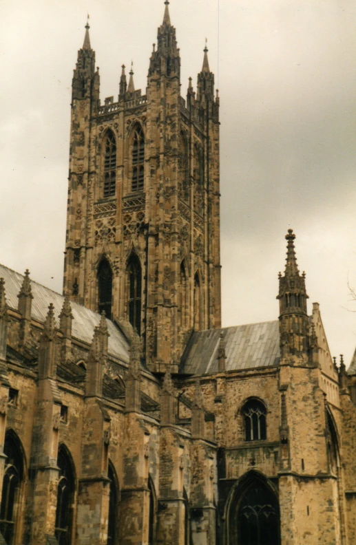 a cathedral with a large clock tower under a gray sky