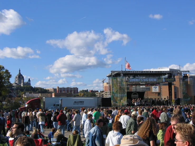 a group of people walking around an outdoor concert