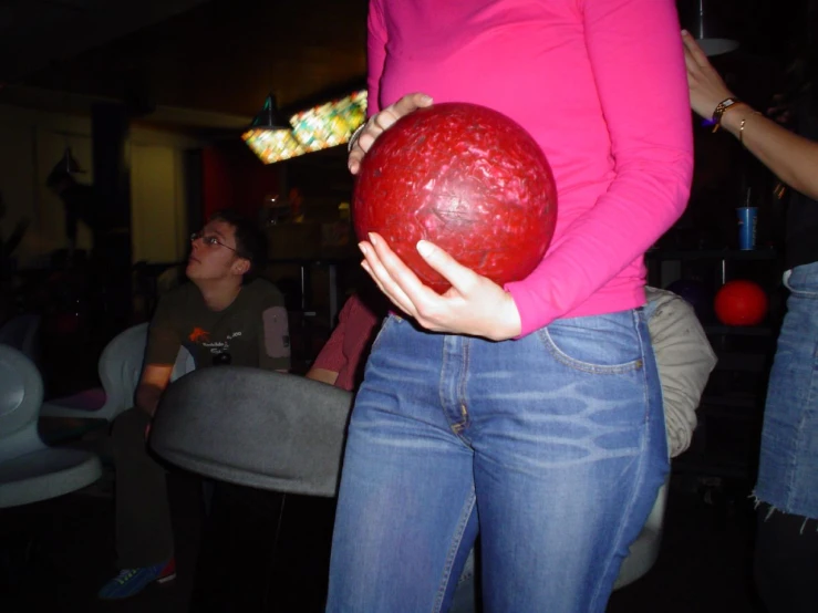 the woman is holding a bowling ball in her hands