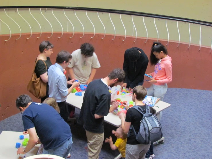 a bunch of people standing around a table full of cubes