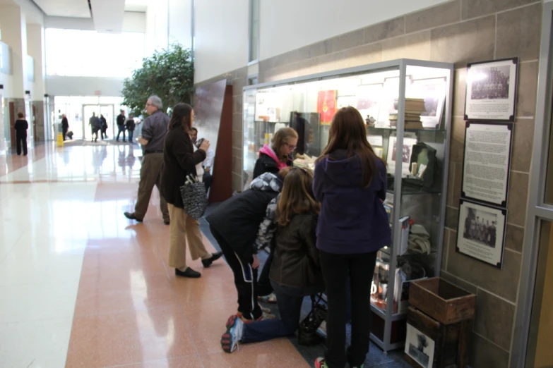 a group of people are looking at things on display in the lobby