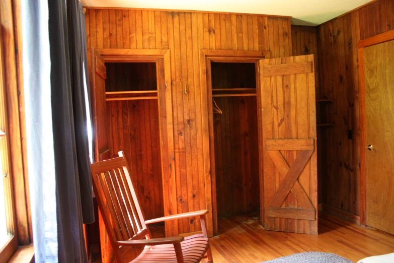 a wood room has two doors and a rocking chair