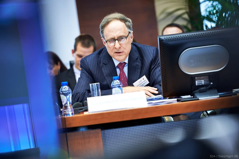 a man in a suit is at a meeting