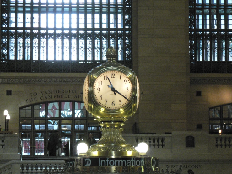 a large golden clock mounted inside of a building