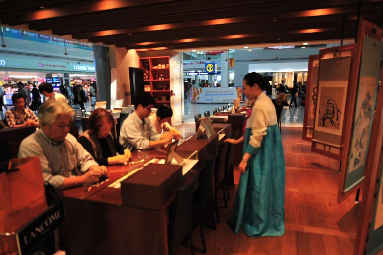 people are sitting at the counter of an oriental restaurant