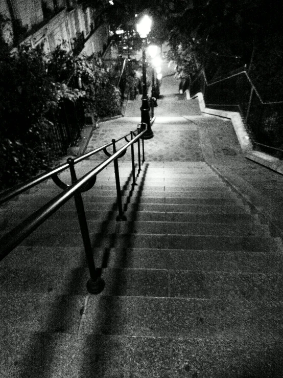 a black and white pograph of a long walkway at night