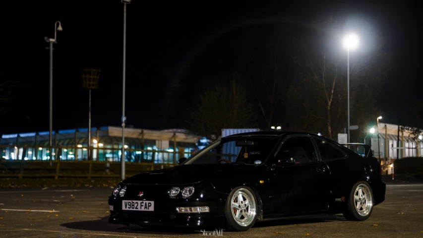 a very nice looking car parked in a lot by some tall buildings