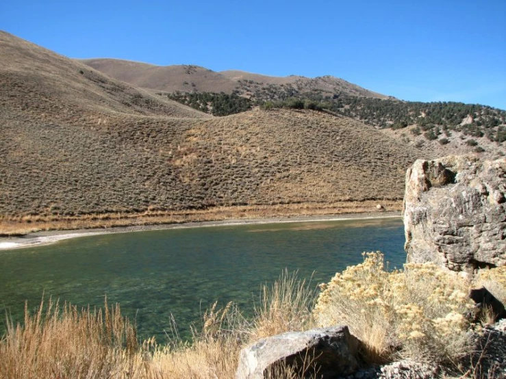 the water is still cold and green near many mountains