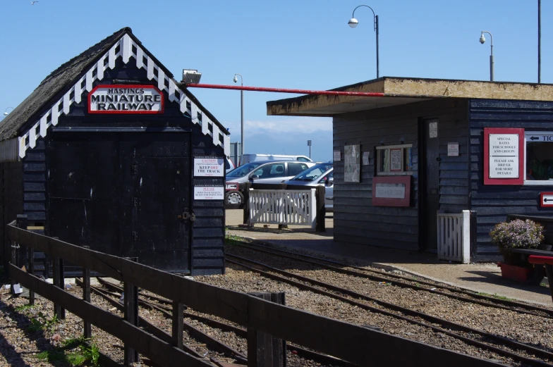a small train station is made of black wood
