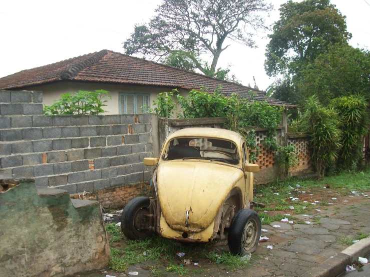 a car sitting outside of a brick building next to a wall
