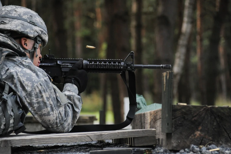 an army soldier aims a machine to its target