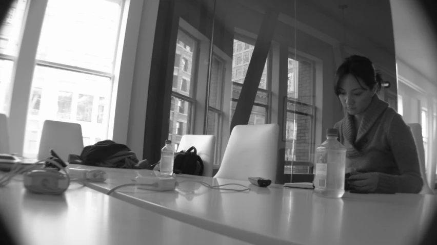 a young woman seated at a table in front of laptop