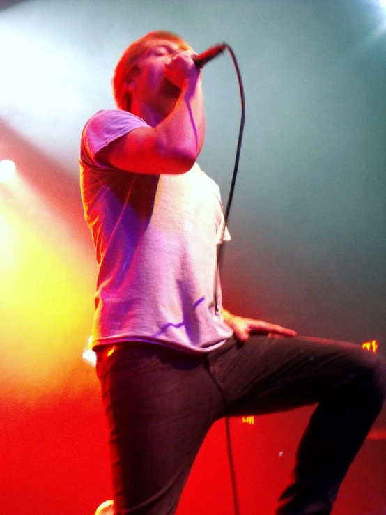 a man standing on top of a stage holding a microphone