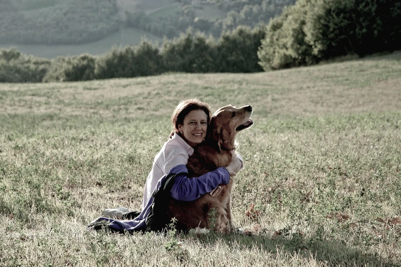 an image of a woman holding her dog in the grass