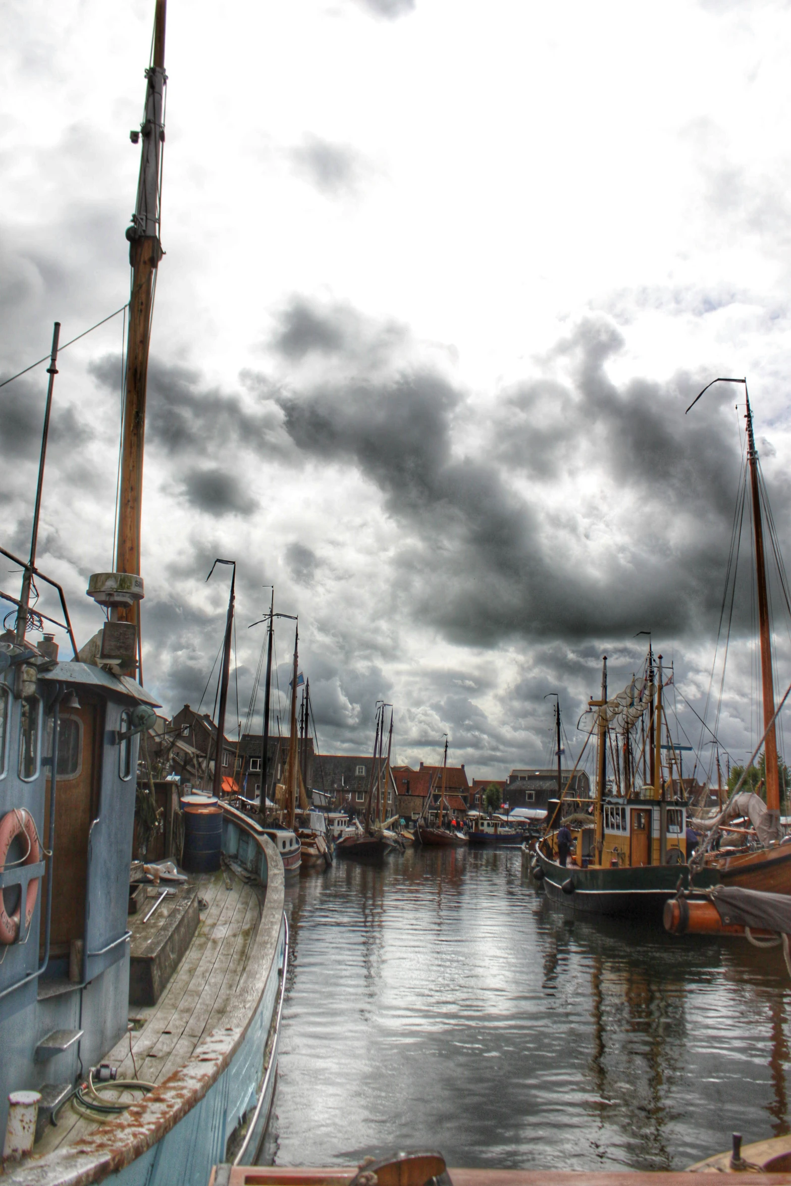 a body of water with boats and a sky filled with clouds