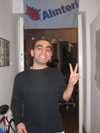 a man smiling and making the middle finger sign with his hand