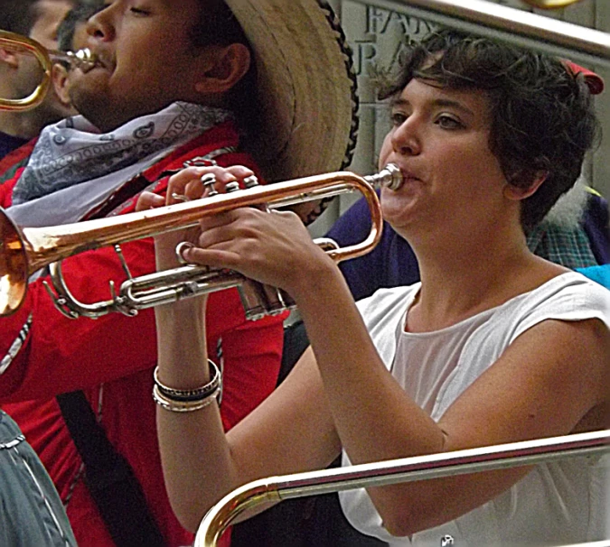 a man and woman play trumpets with other people